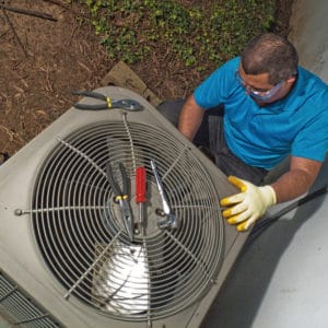 Technician installing an A/C unit on a home in Rockwall.